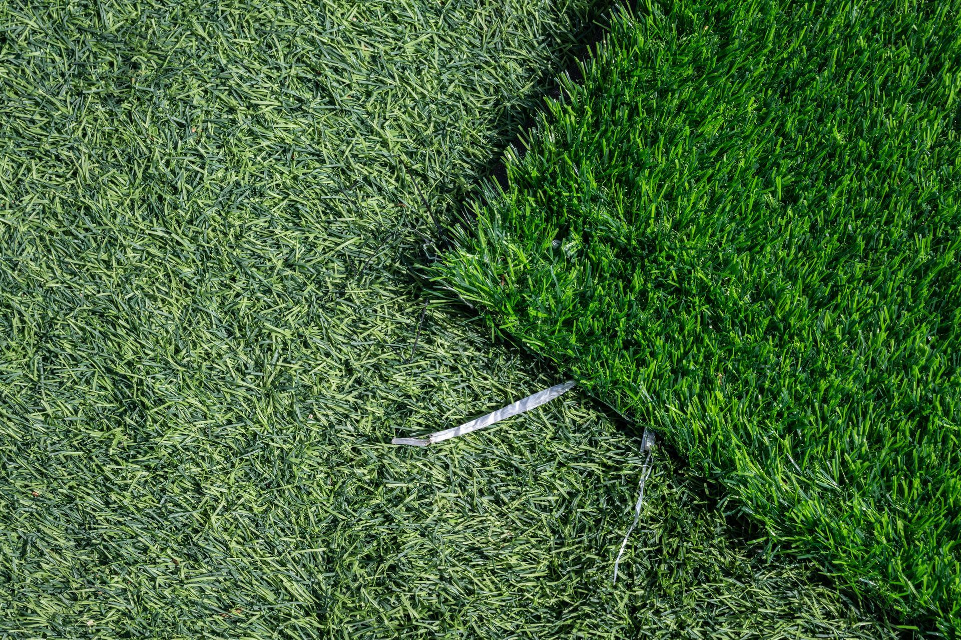 A close up of a piece of artificial grass on a soccer field.