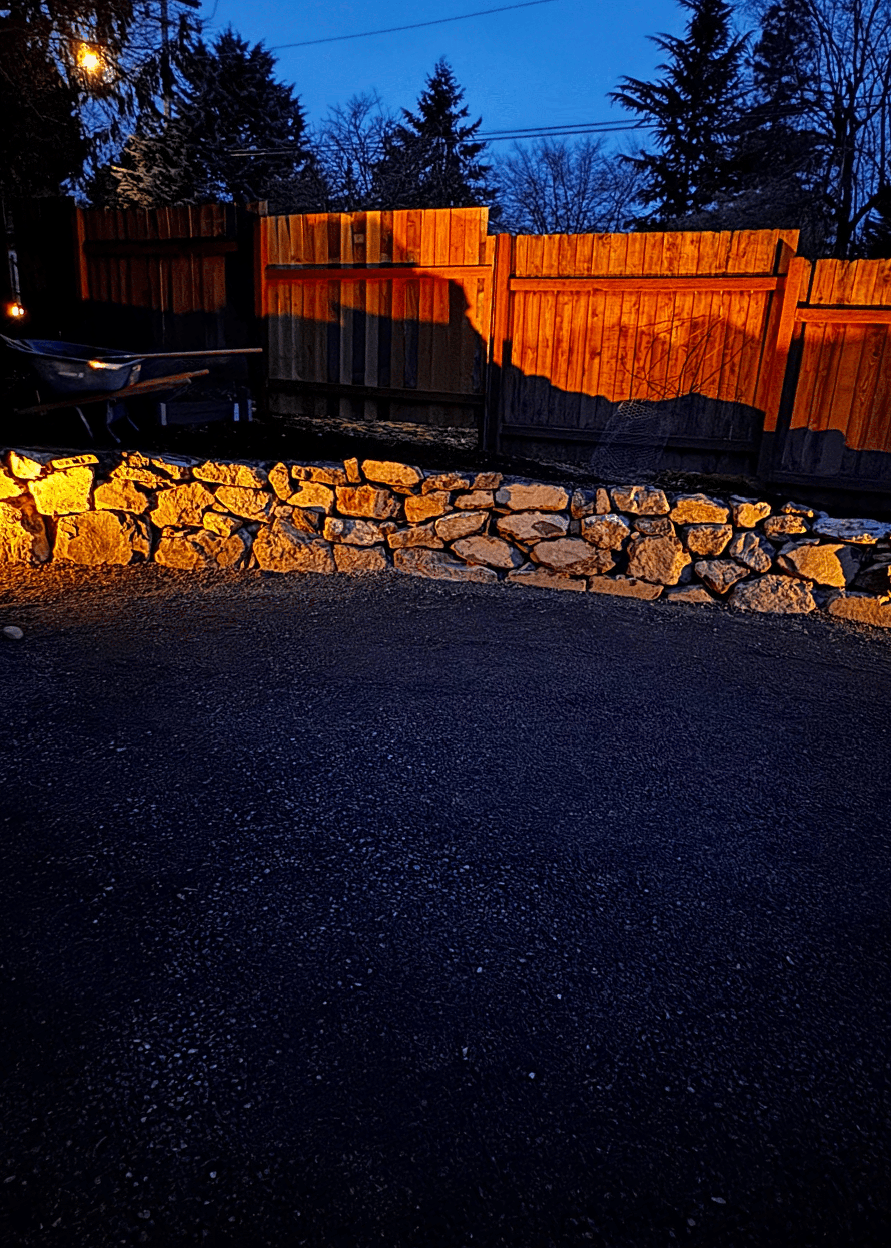 A wooden fence with a stone wall in front of it