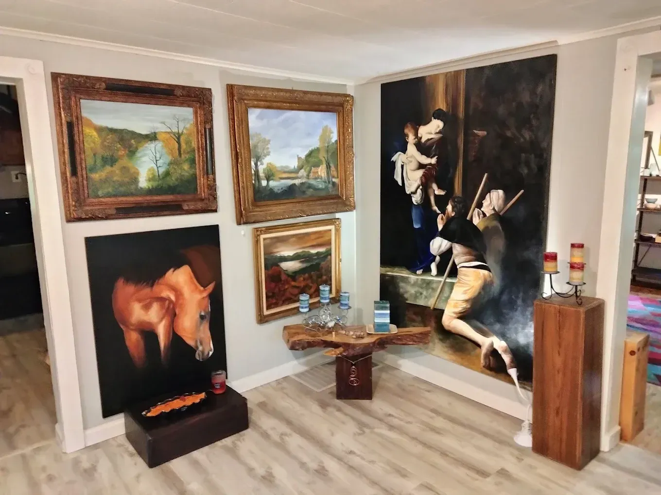 A room filled with paintings and a wooden floor.