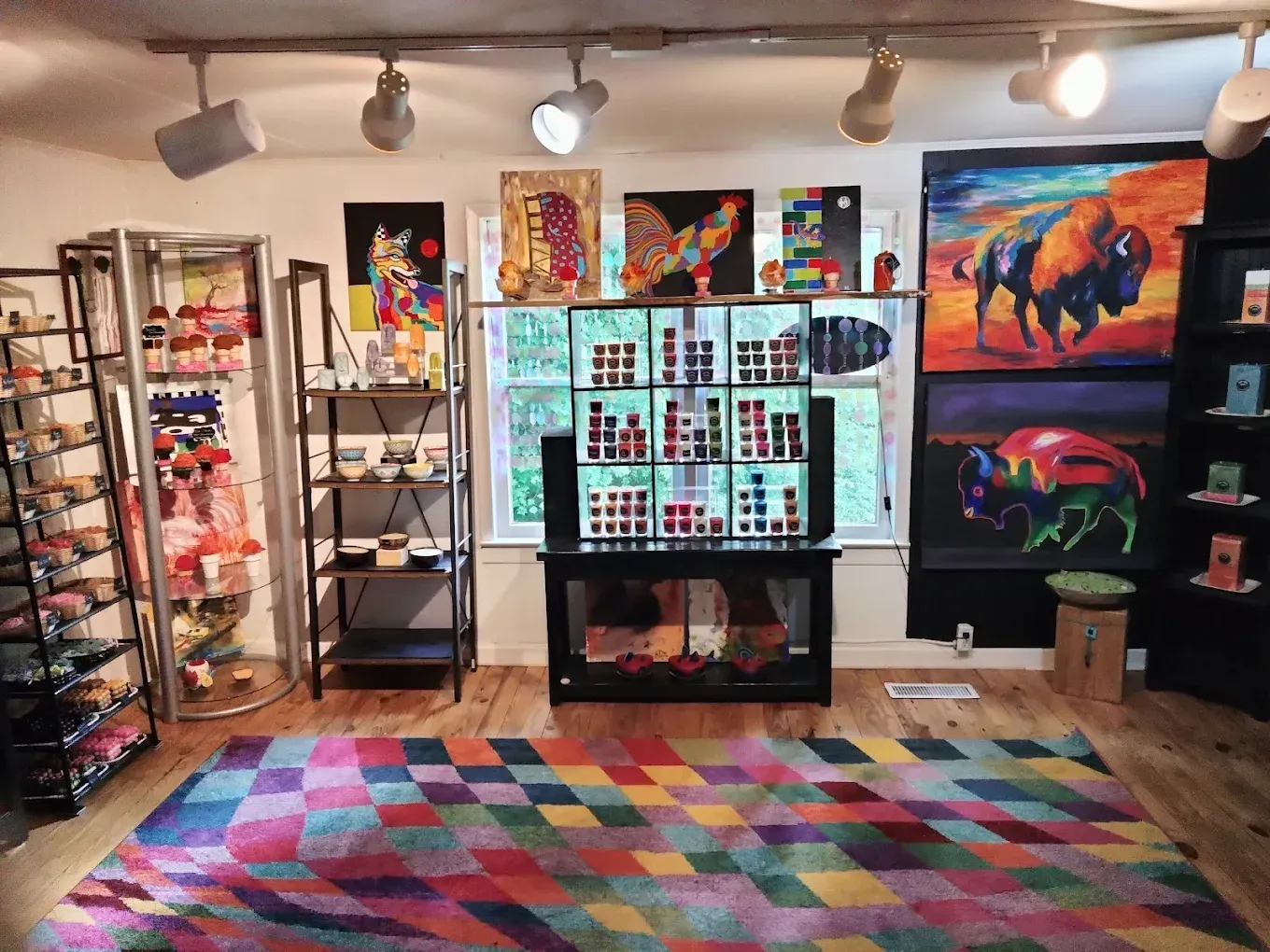 A room with a colorful rug and paintings on the wall