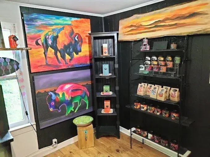 A room with a lot of paintings on the wall and shelves.