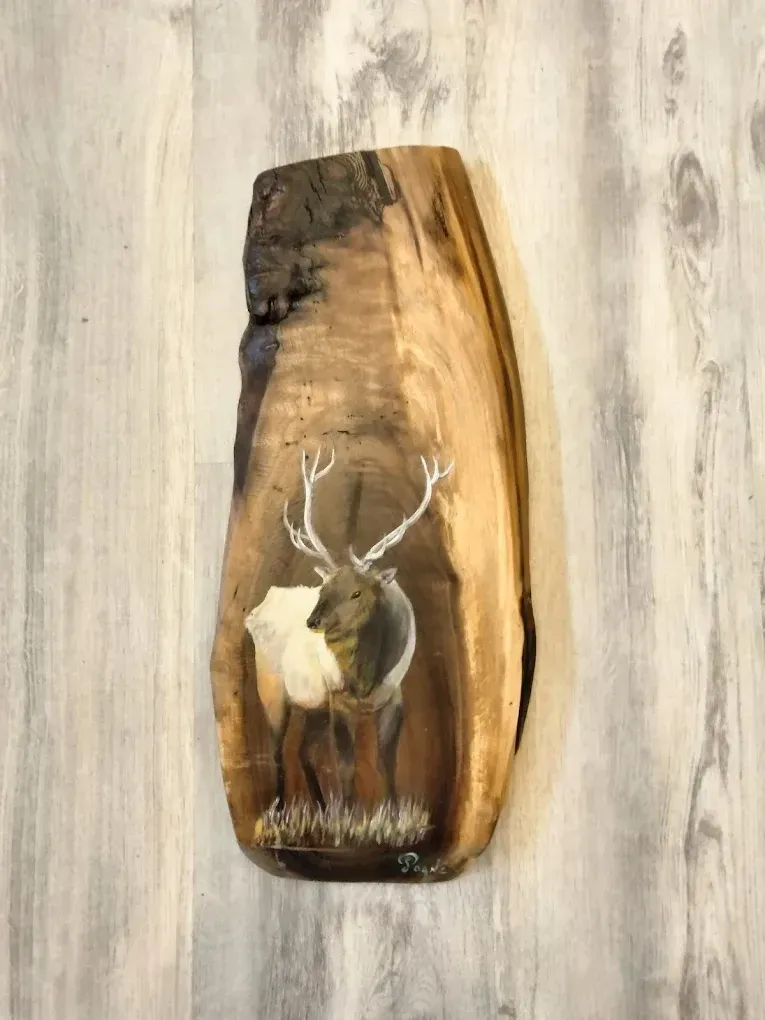 A piece of wood with a picture of a deer on it.