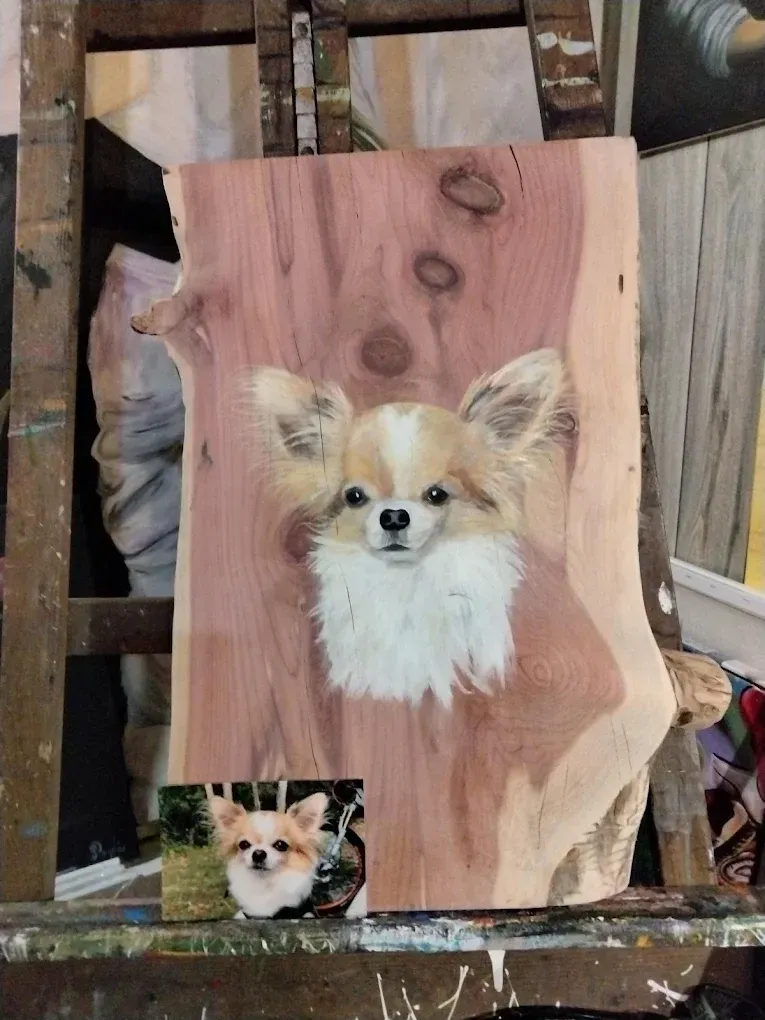 A painting of a chihuahua on a piece of wood on an easel.