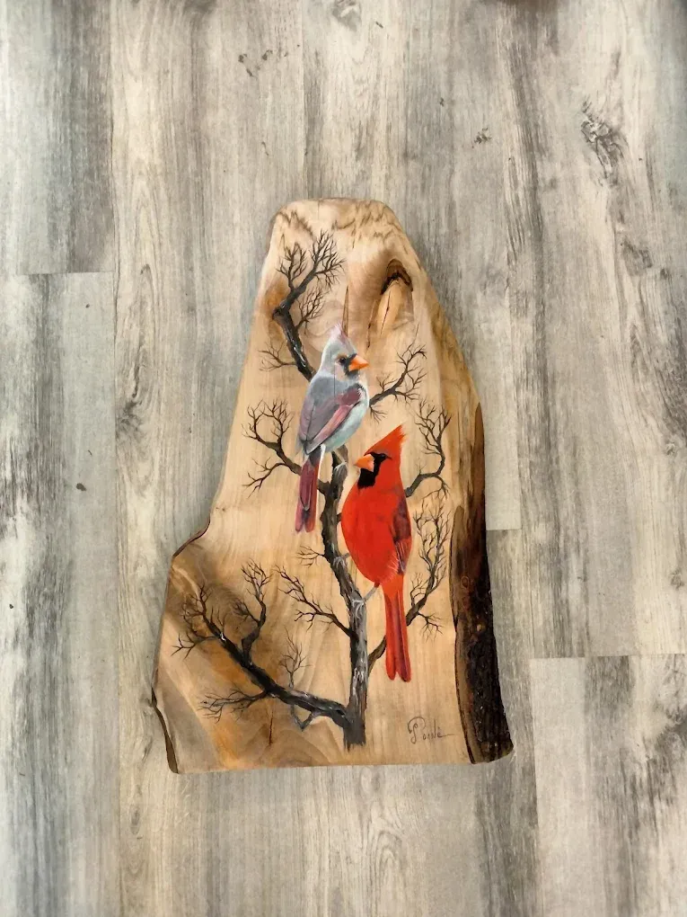 A piece of wood with two cardinals sitting on a tree branch.