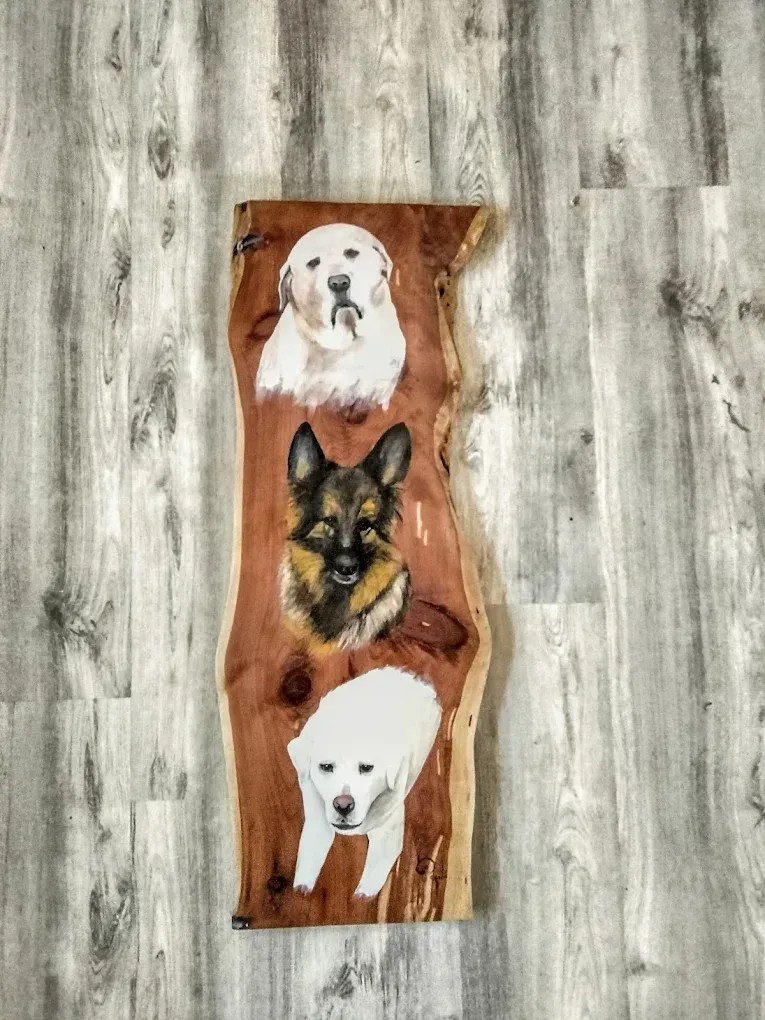 Three dogs are painted on a piece of wood.