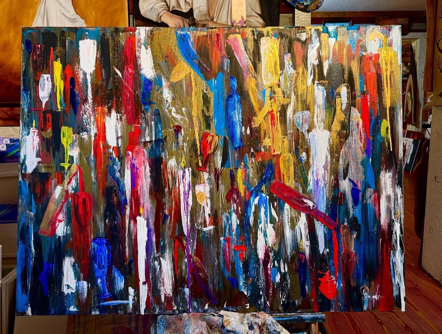 A large colorful painting is sitting on an easel.