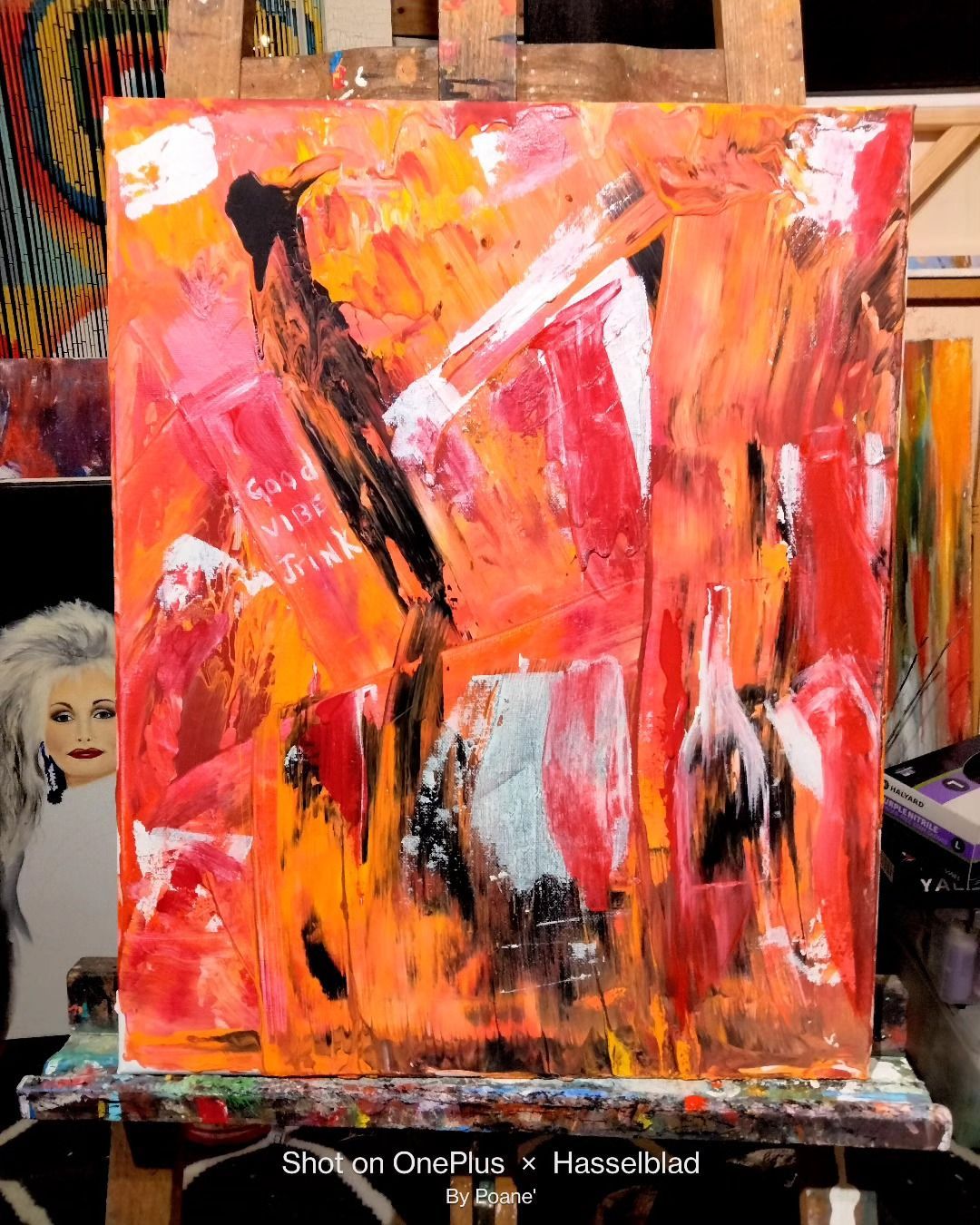 A colorful painting is sitting on a wooden easel.