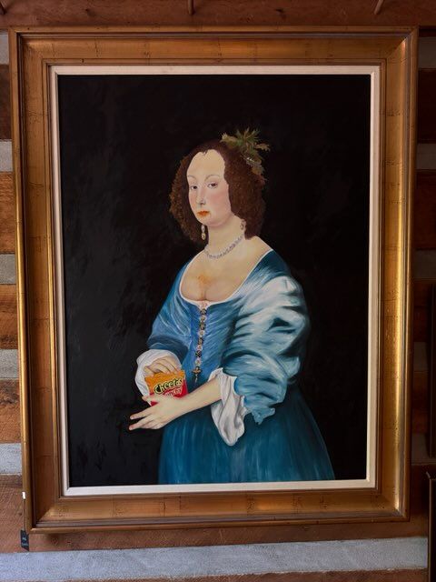 A framed painting of a woman in a blue dress
