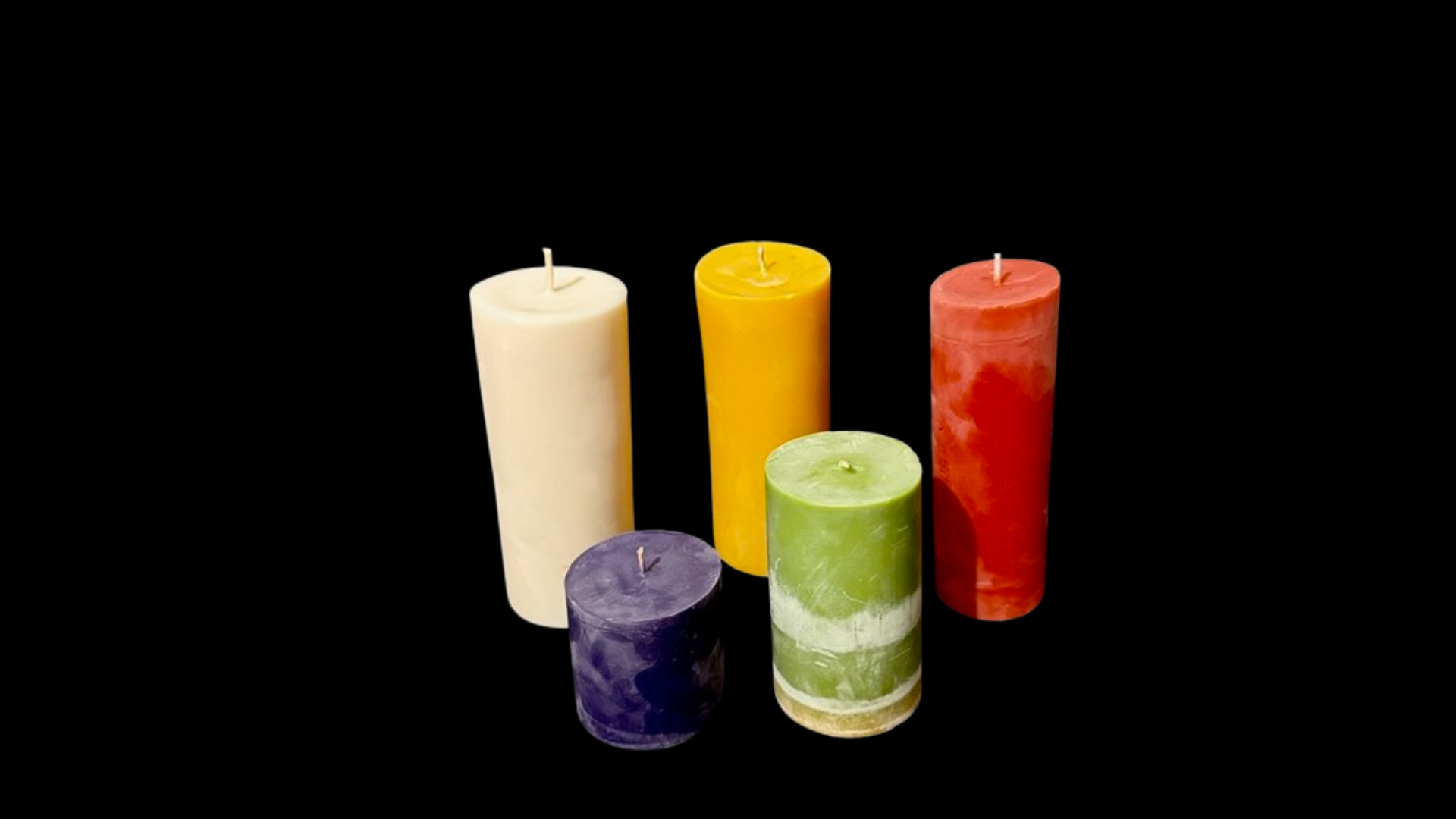 A group of colorful candles are sitting next to each other on a black background.
