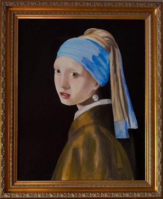 A framed painting of a girl with a pearl earring