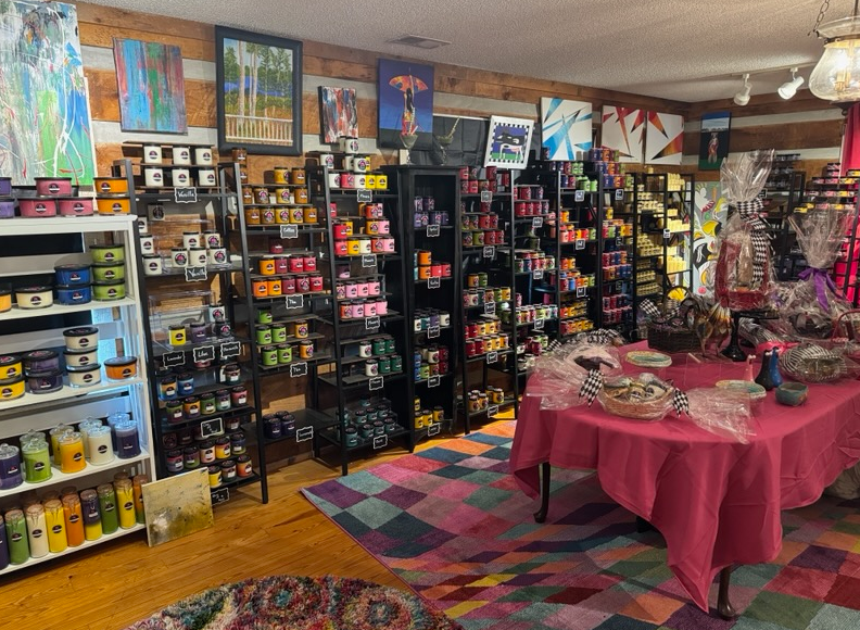 A room filled with lots of shelves and a table with a pink tablecloth.