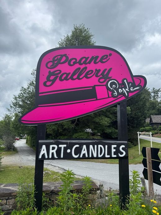 A sign that says poane gallery art candles on it