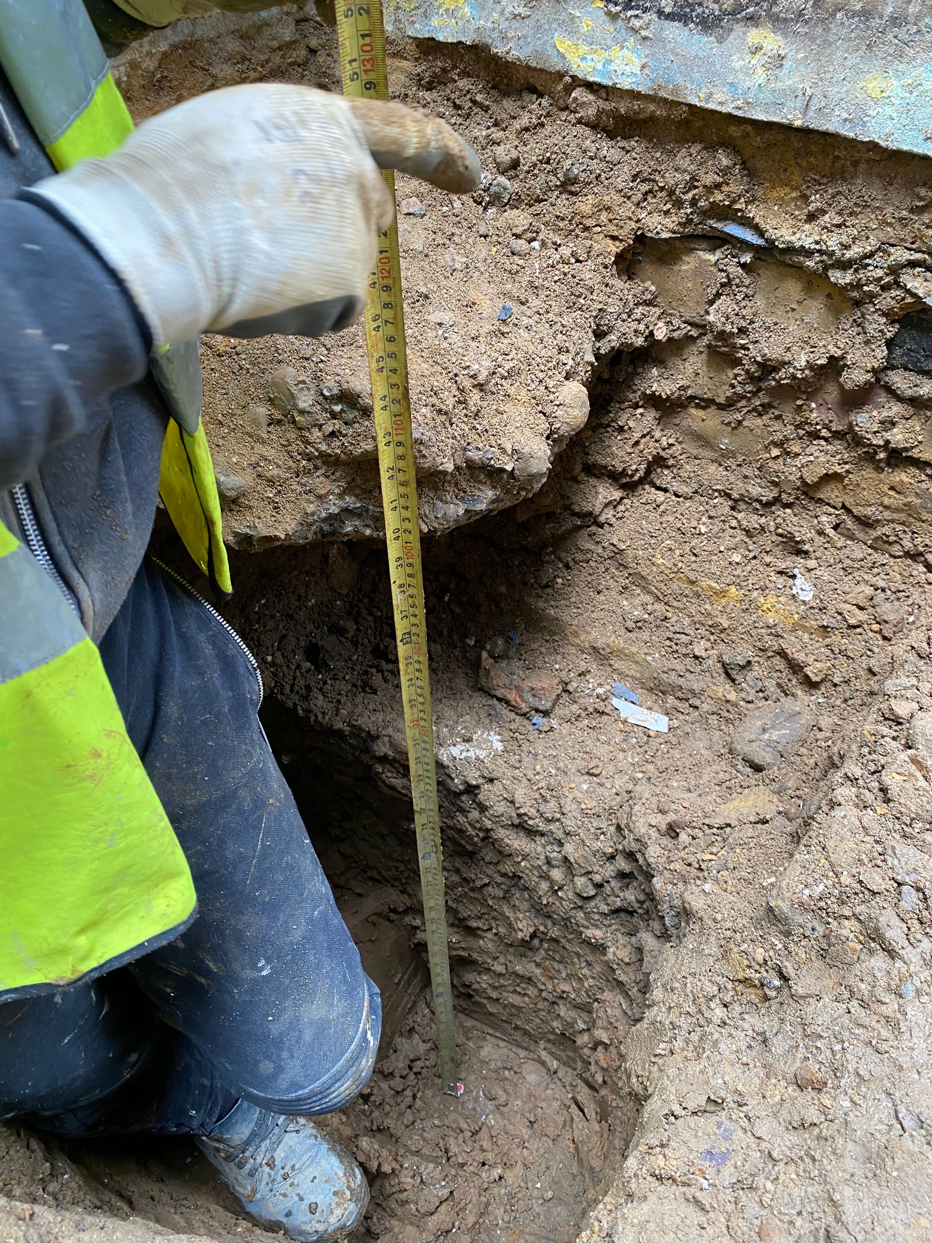 Measuring foundation depth for a Walthamstow E17 kitchen extension by Ibex Builders.