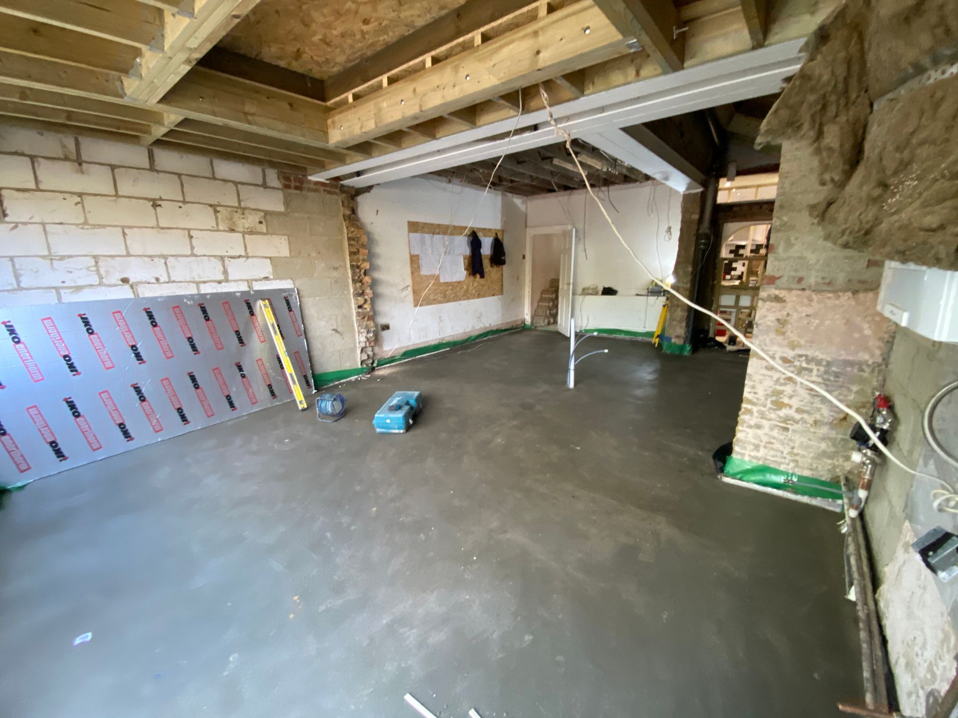 Spacious open-plan kitchen extension shell with completed flooring by Ibex Builders in E17.