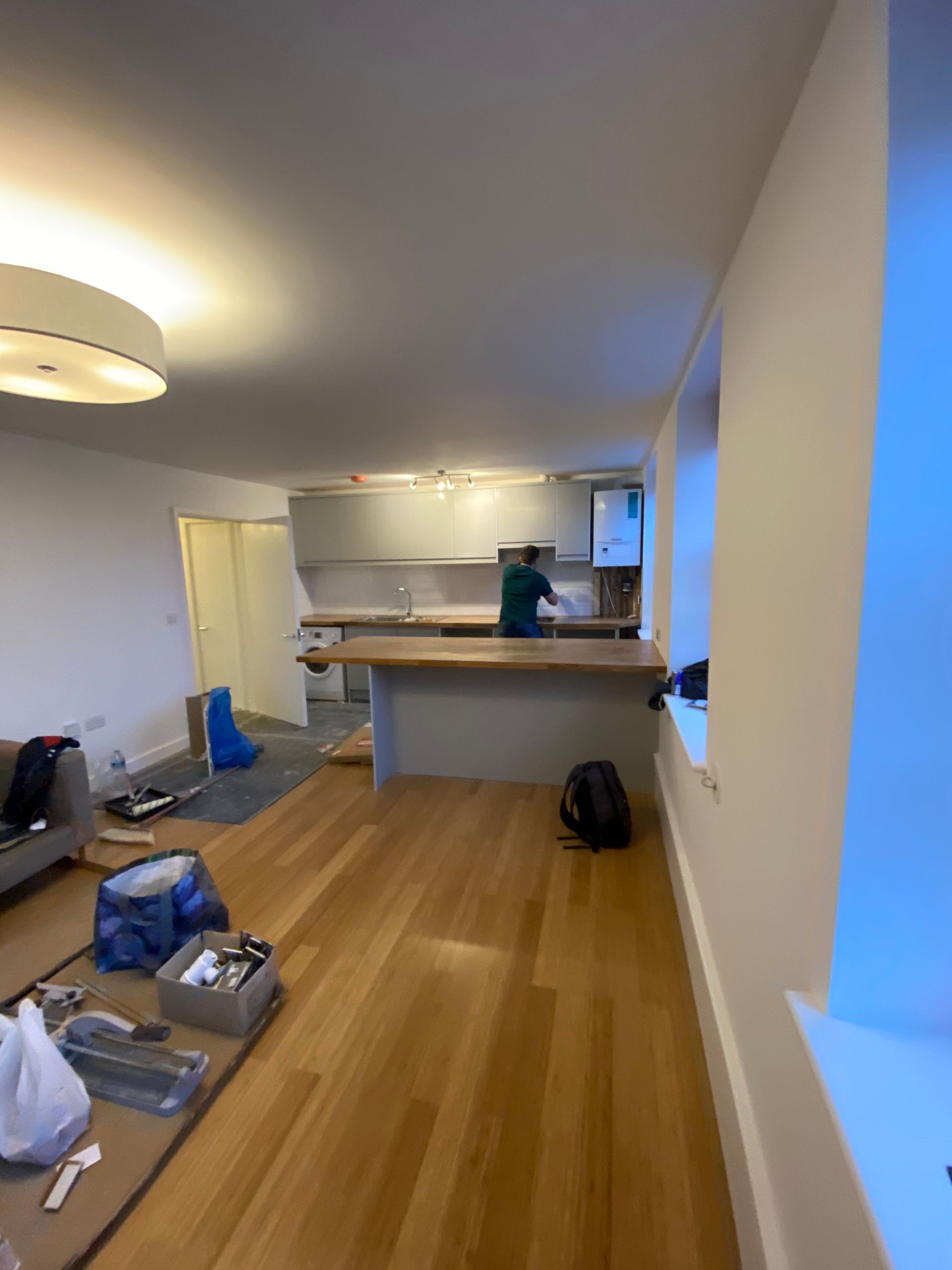 Open-plan interior view showing the modern layout of a renovated Hackney E5 flat with sleek lighting.