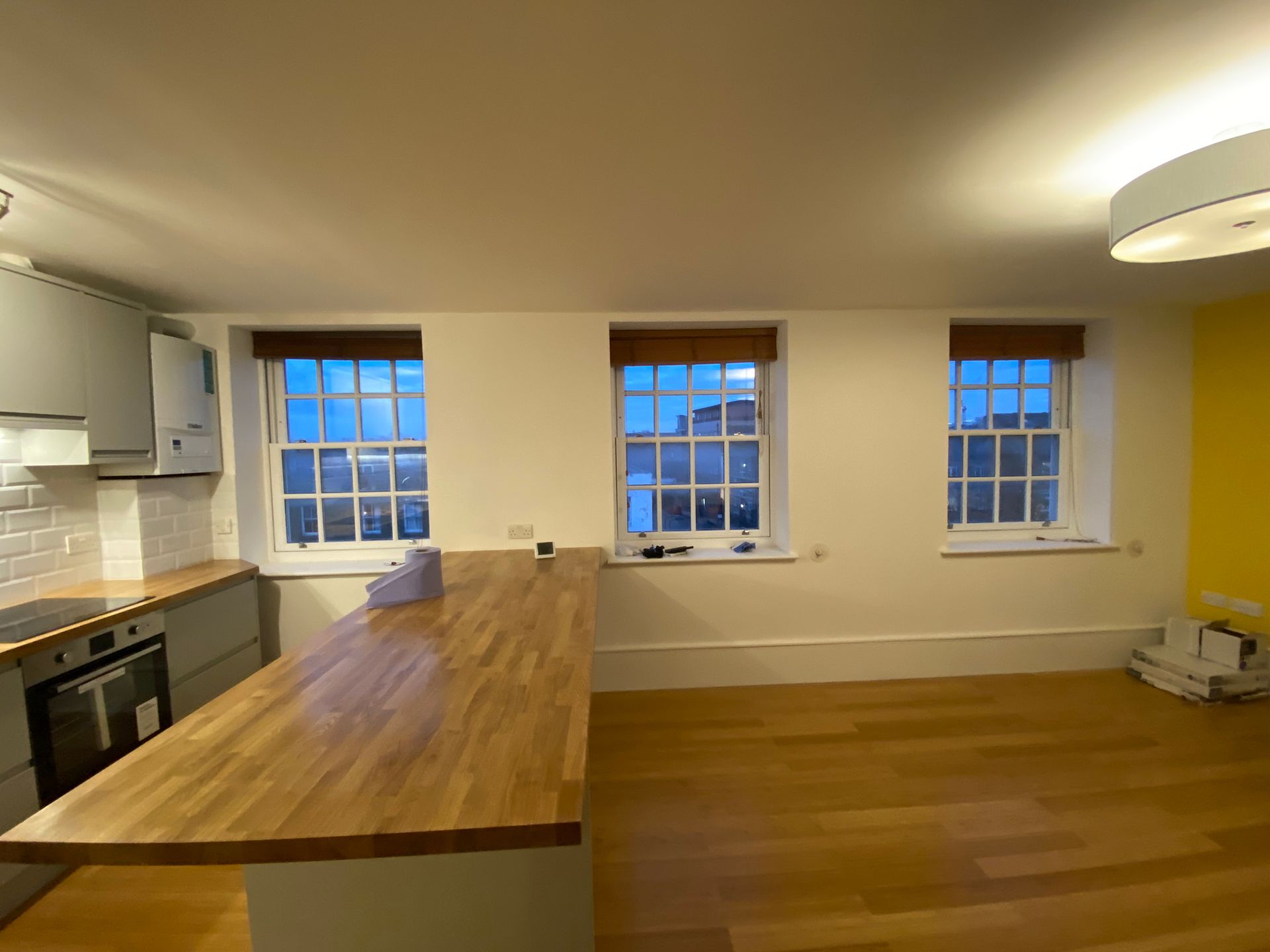 Bright open-plan living area with wood flooring and sash windows in a Hackney E5 property renovation.