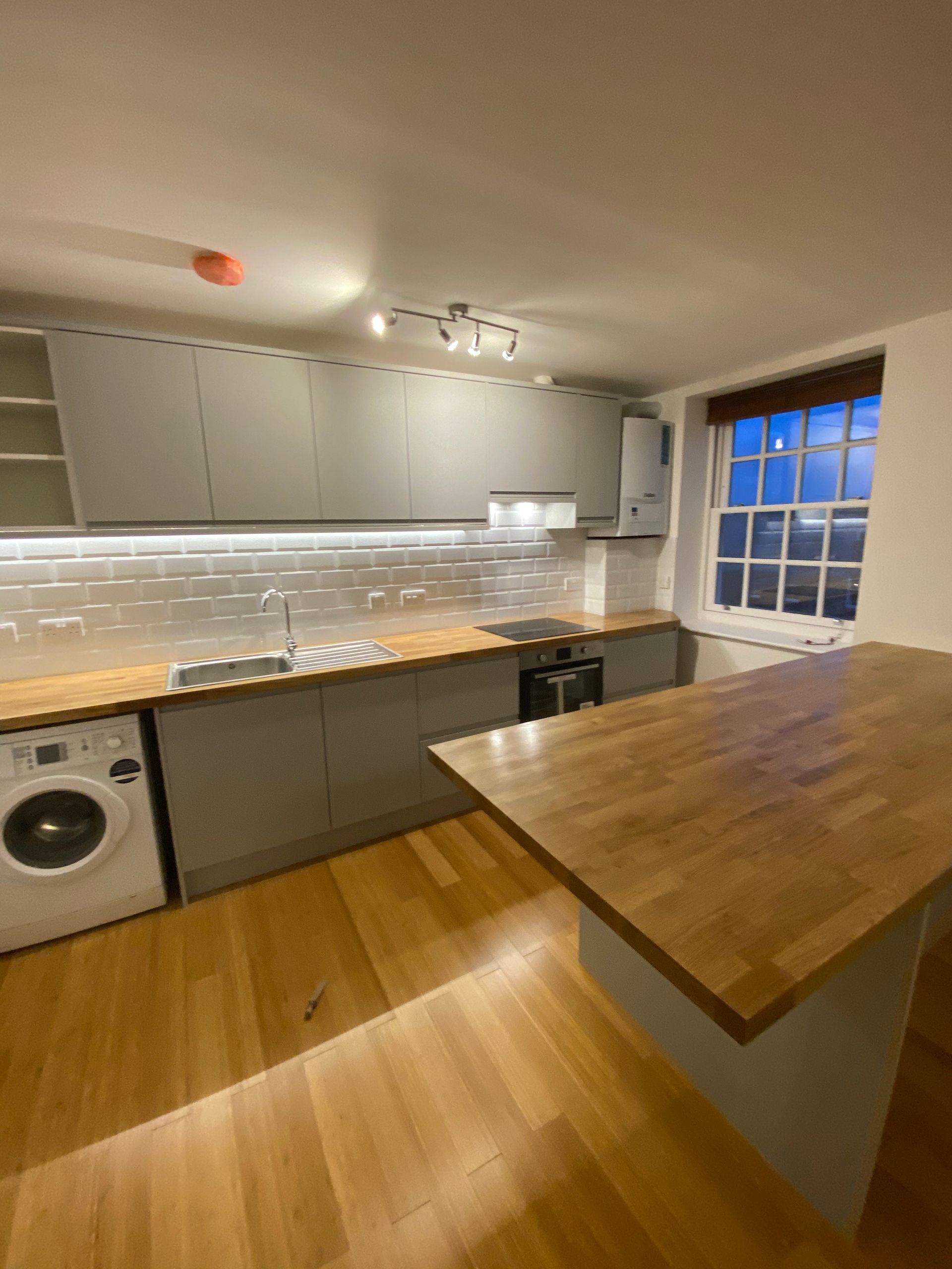 High-end kitchen cabinetry and modern lighting design in a Hackney E5 flat conversion and renovation.