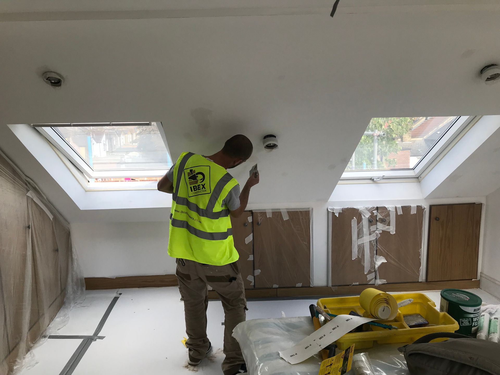 Ibex Builders decorating a new loft conversion interior featuring professional skylight installations.