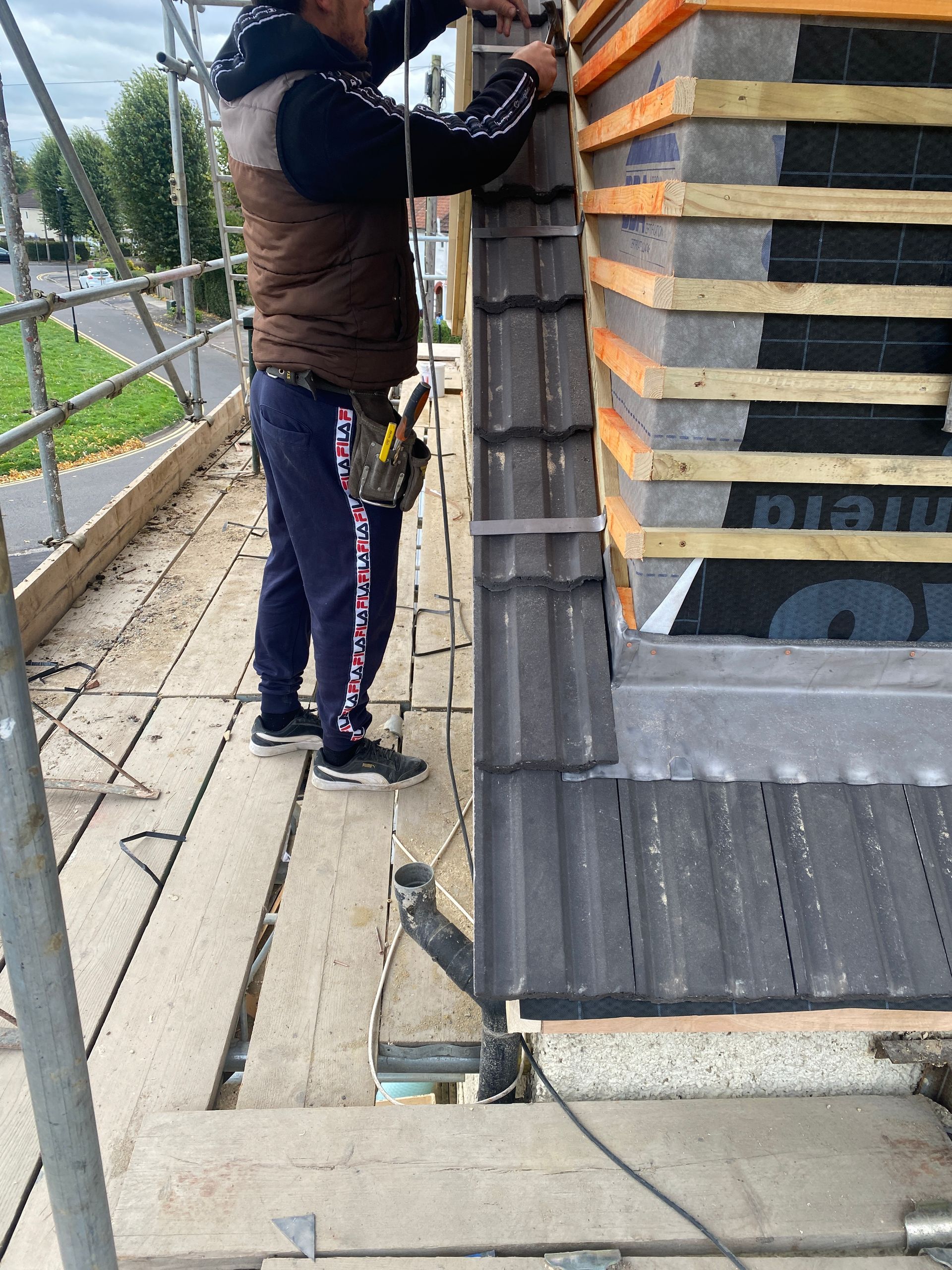 Skilled Ibex Builders contractor working on the exterior structure of a residential loft conversion.