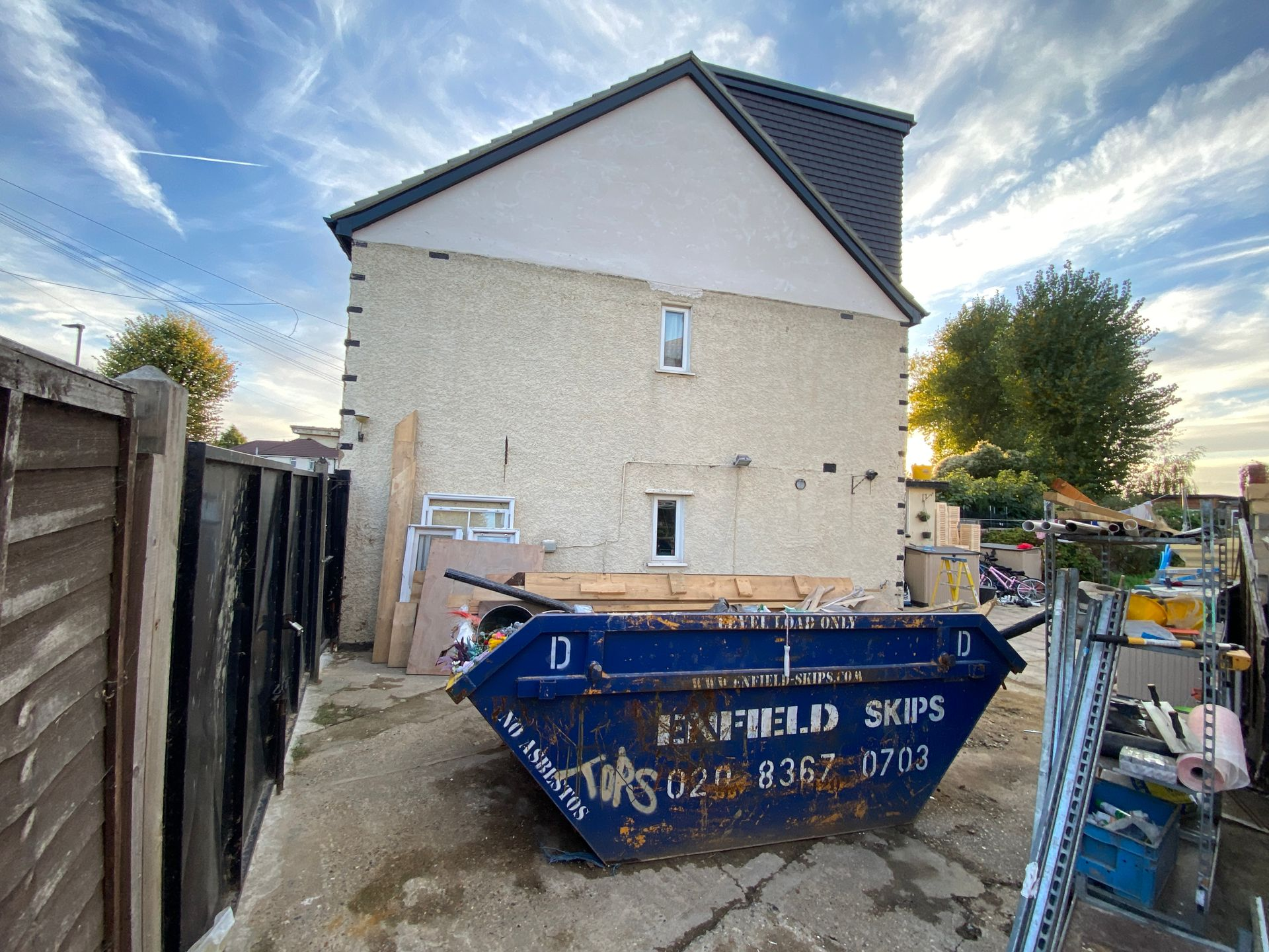 Exterior of a semi-detached house during a loft conversion in Broadfield Square with a construction skip.