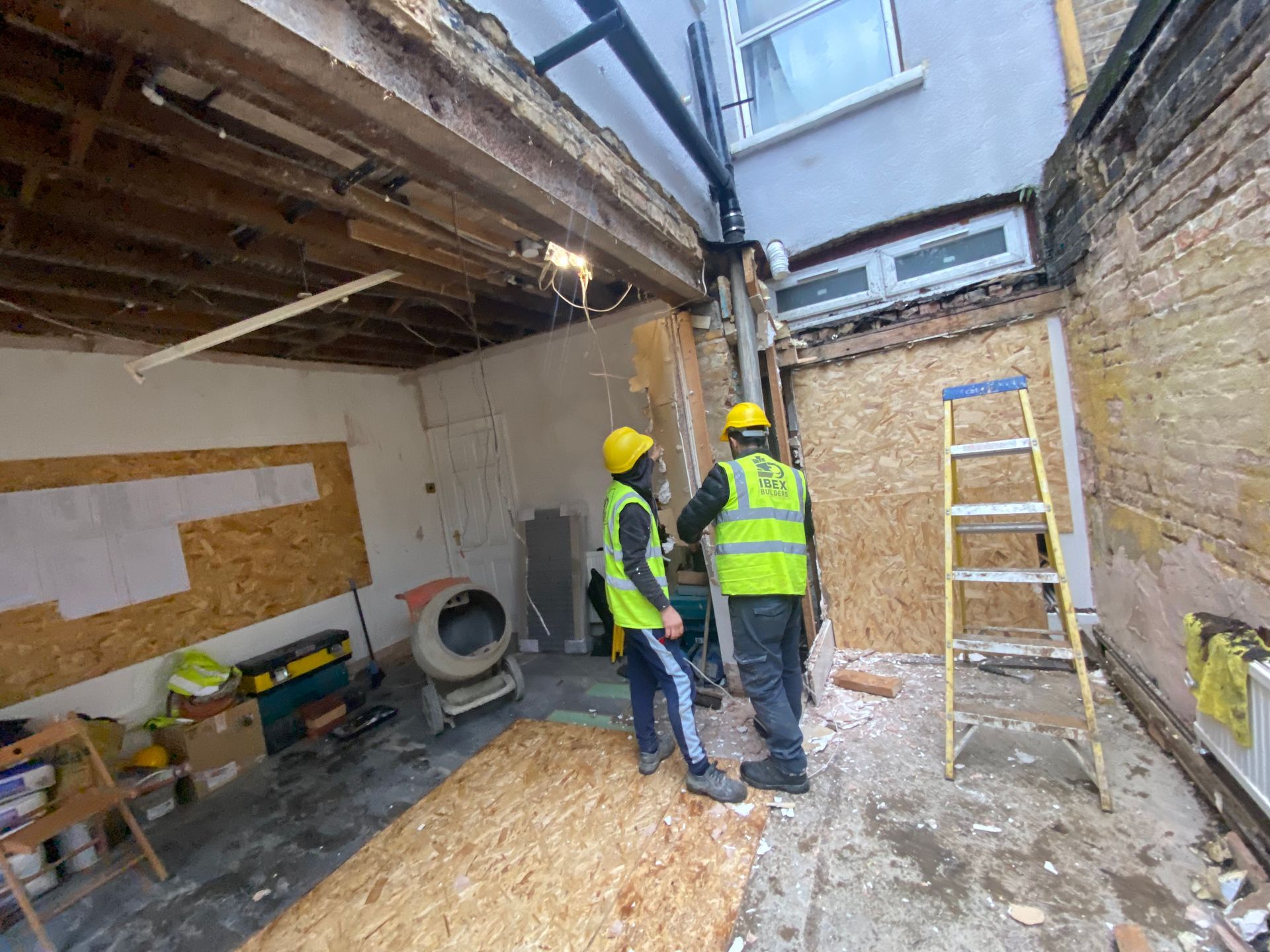 Ibex Builders team discussing structural plans inside a Walthamstow E17 kitchen extension.
