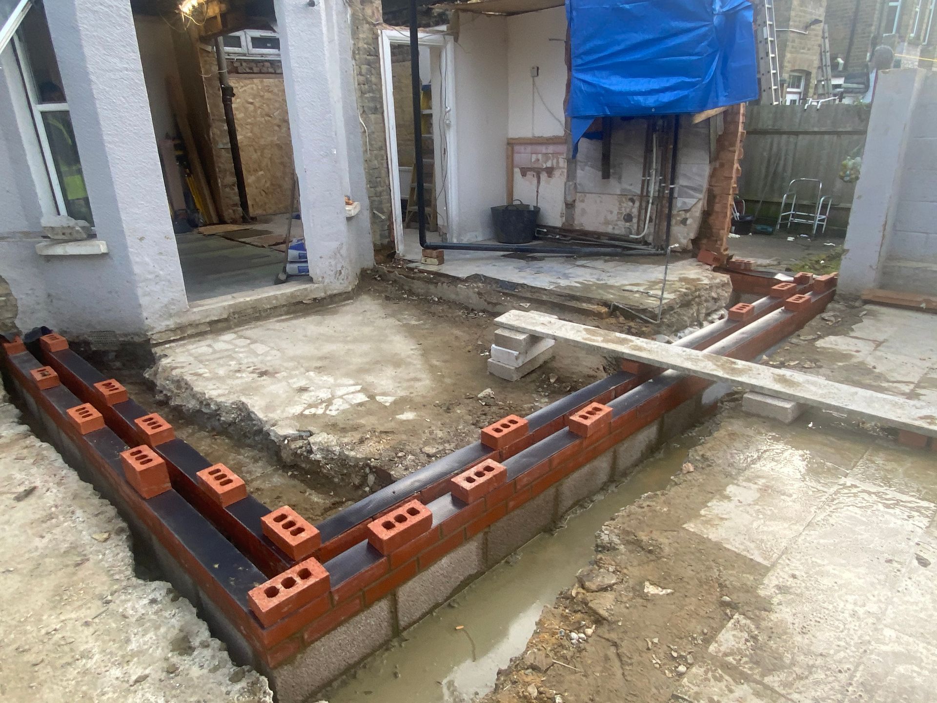 Ibex Builders team preparing floor slab and brick footings for an E17 home extension.