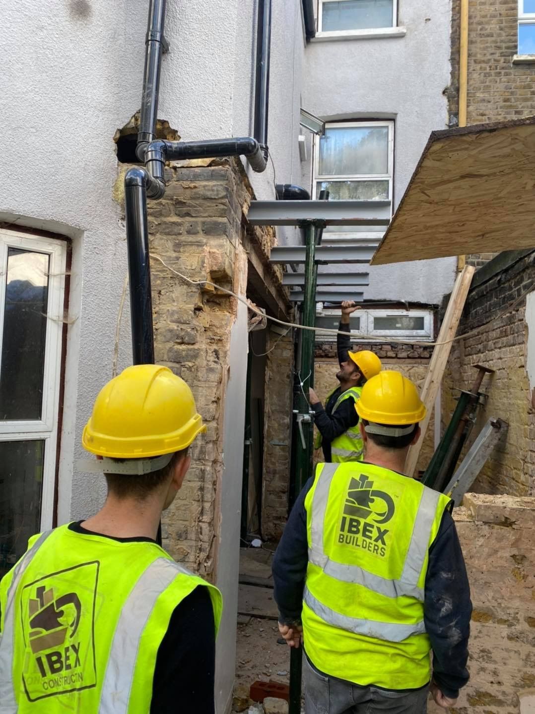 Ibex Builders team assessing exterior structural steelwork for a rear home extension in Walthamstow.