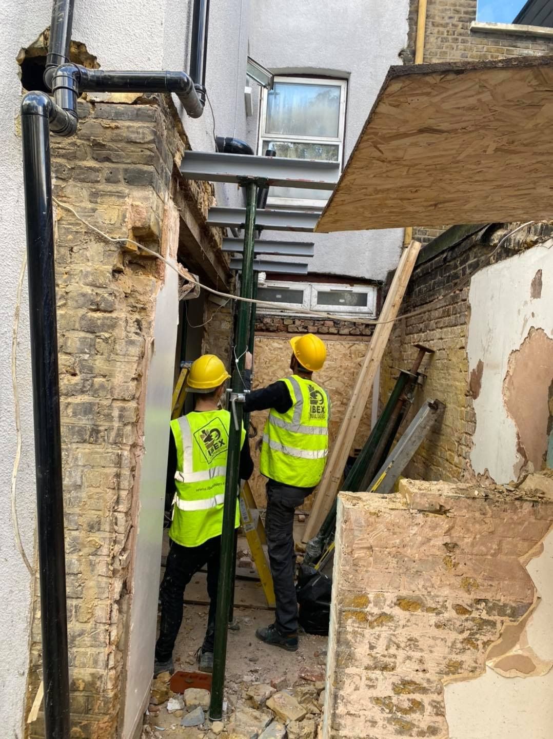Professional Ibex Builders team fitting external steel supports for an E17 kitchen renovation.