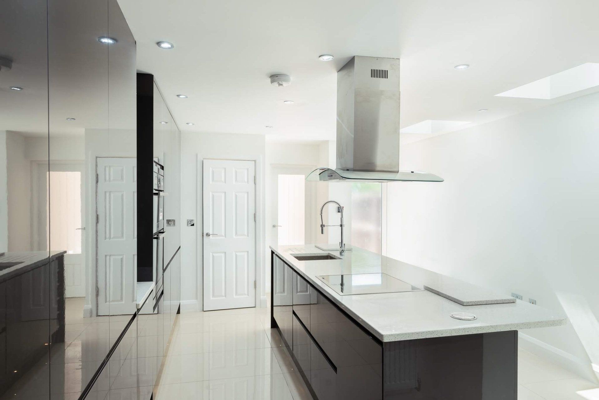 Sleek grey kitchen extension with large central island in Walthamstow by Ibex Builders.