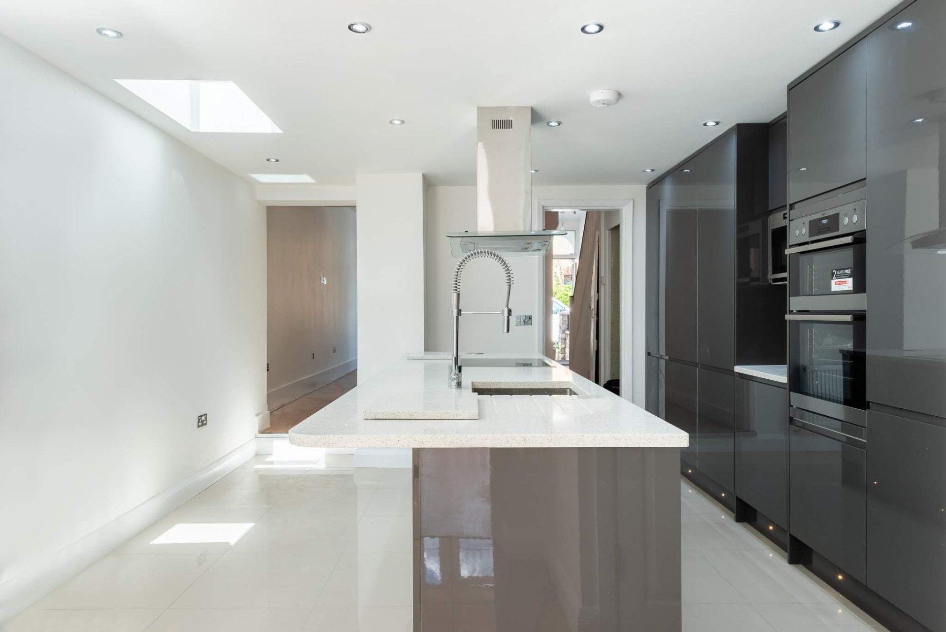 Modern kitchen island with white worktops in a Walthamstow extension by Ibex Builders.
