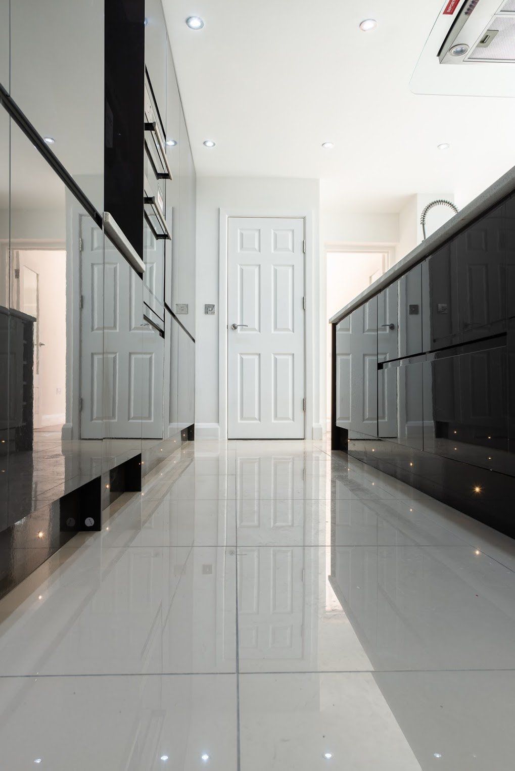 Modern kitchen storage with grey high-gloss cabinets in Walthamstow by Ibex Builders.