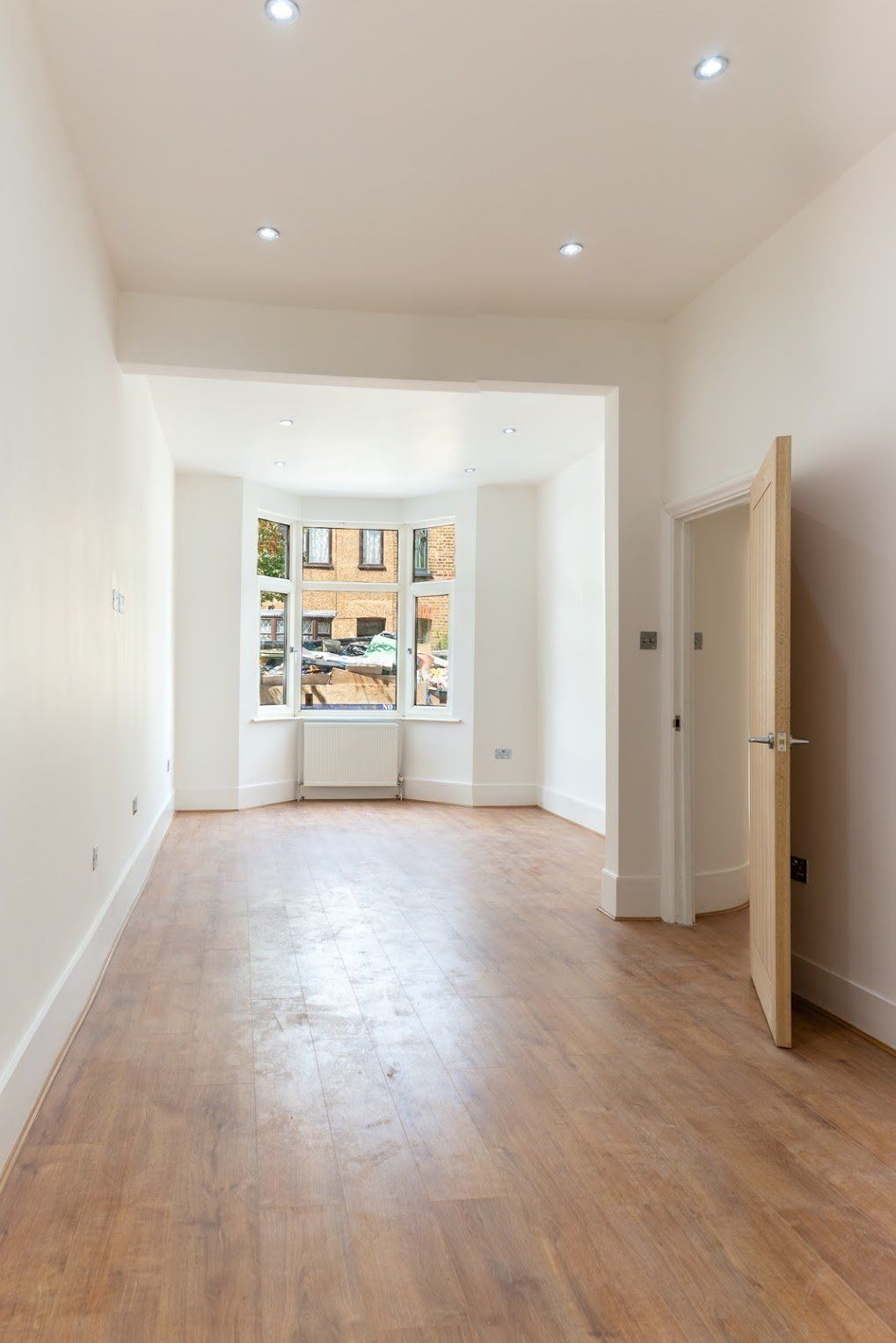 Panoramic view of a newly plastered and lit living space in Walthamstow E17 by Ibex Builders.