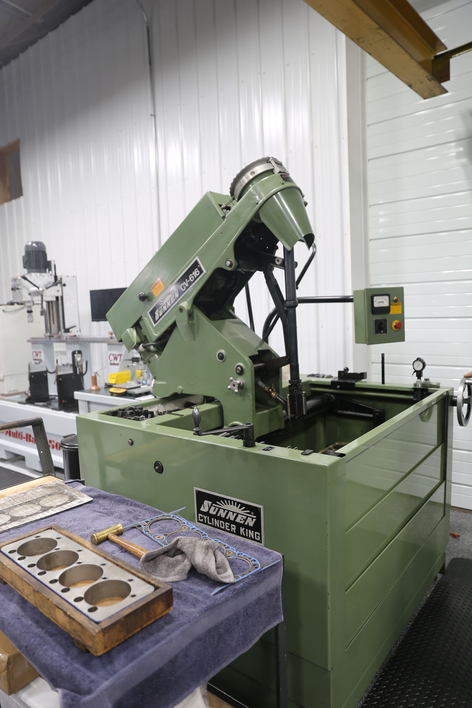 Green electrical discharge machine in a workshop, used to shape metal.