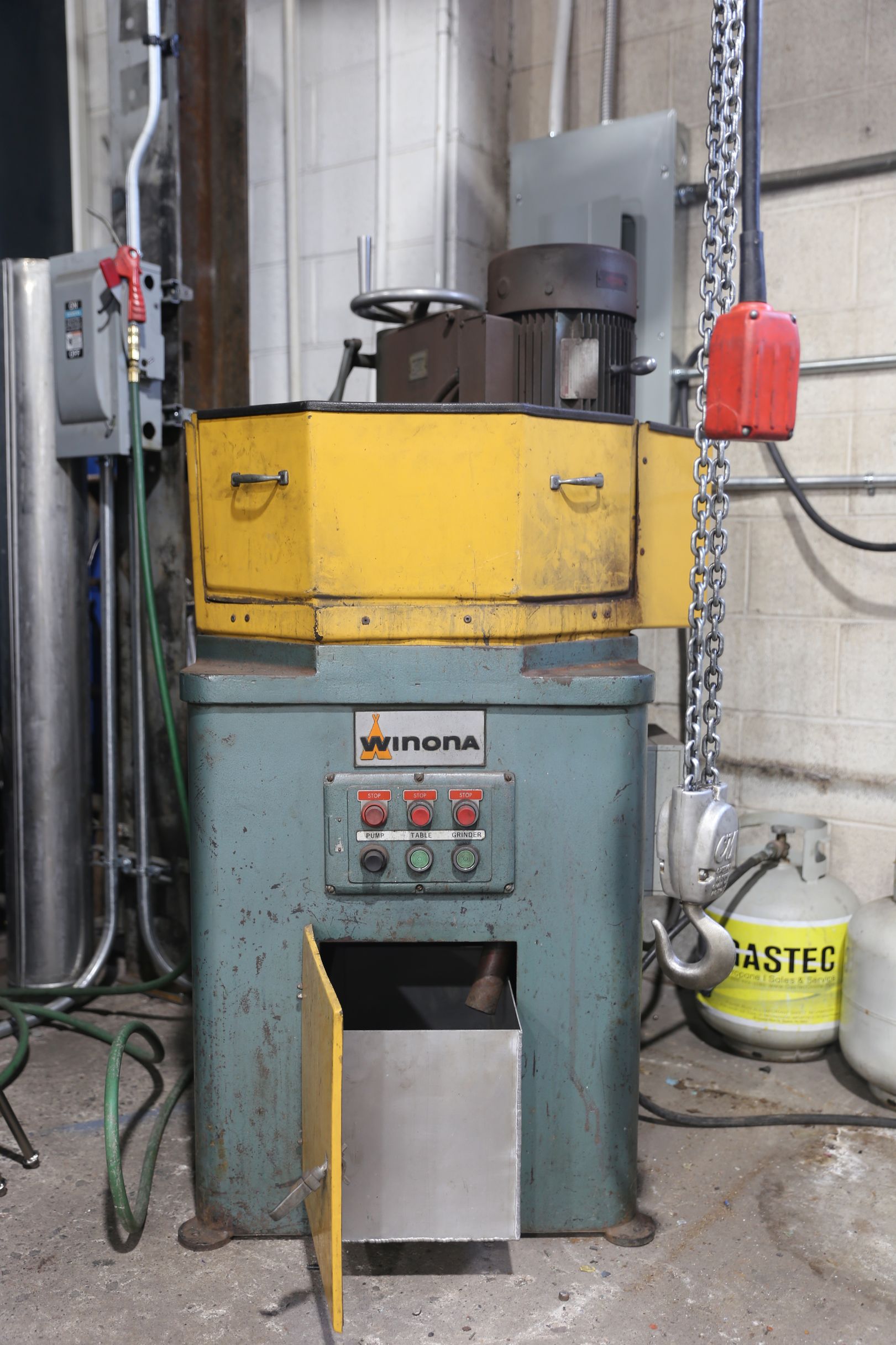 Industrial machine with a yellow top and gray base, likely for grinding or polishing metal.