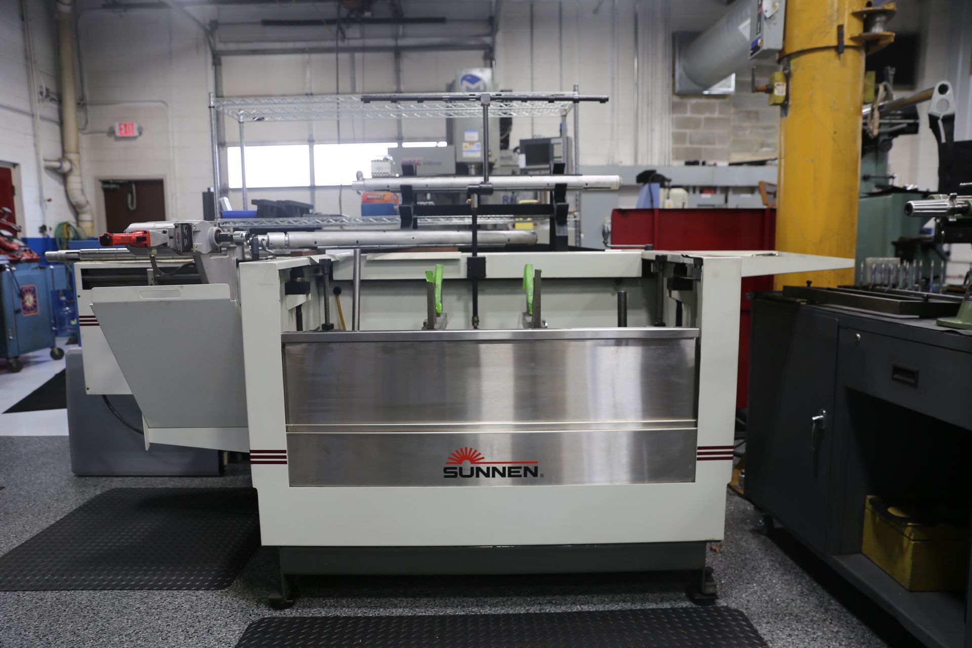 A large, industrial machine with a stainless steel front in a factory setting.