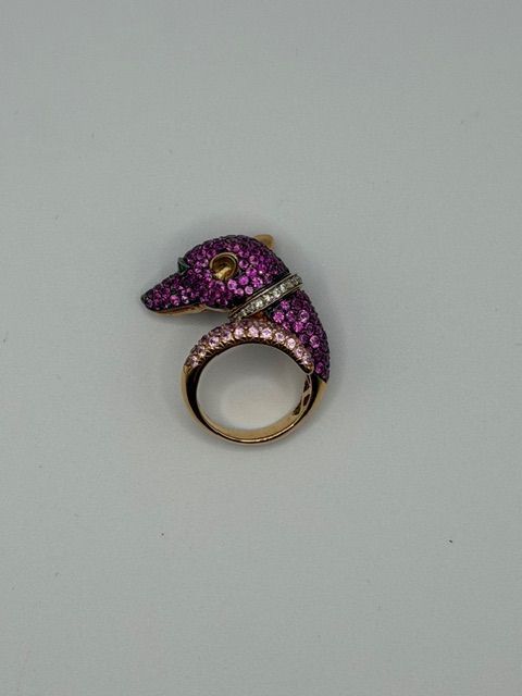 Purple jeweled bird-shaped ring with a gold band on a white background