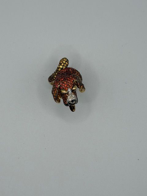 Small red-and-gold decorative animal figurine on a plain gray background