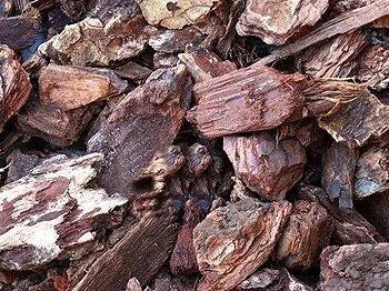 Pile of reddish-brown wood bark mulch.