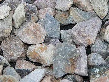 Close-up of mixed-color gravel rocks, including gray, brown, and tan tones.