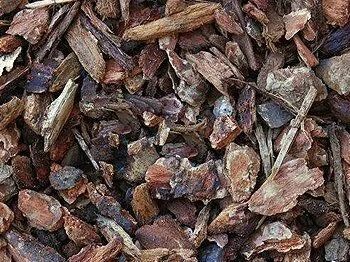 Close-up of brown and tan wood chips, likely mulch, scattered together.