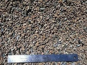Brown gravel stones with a metal ruler for scale.