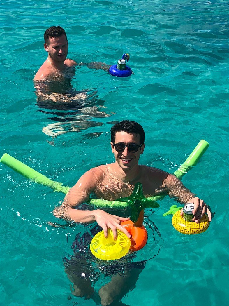 2 men swimming in st maarten, one floating with pool noodle