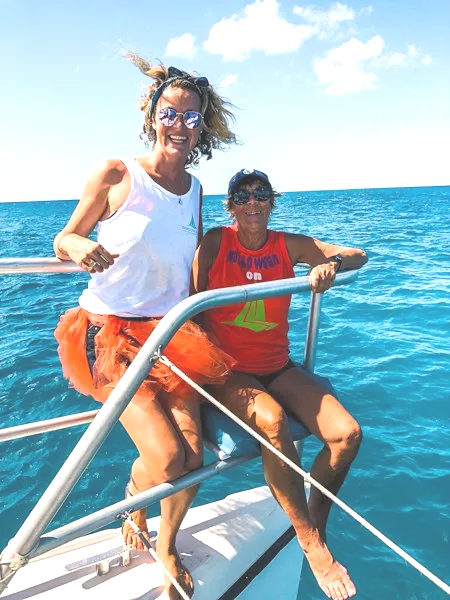 Man and woman sitting at front of catamaran yacht