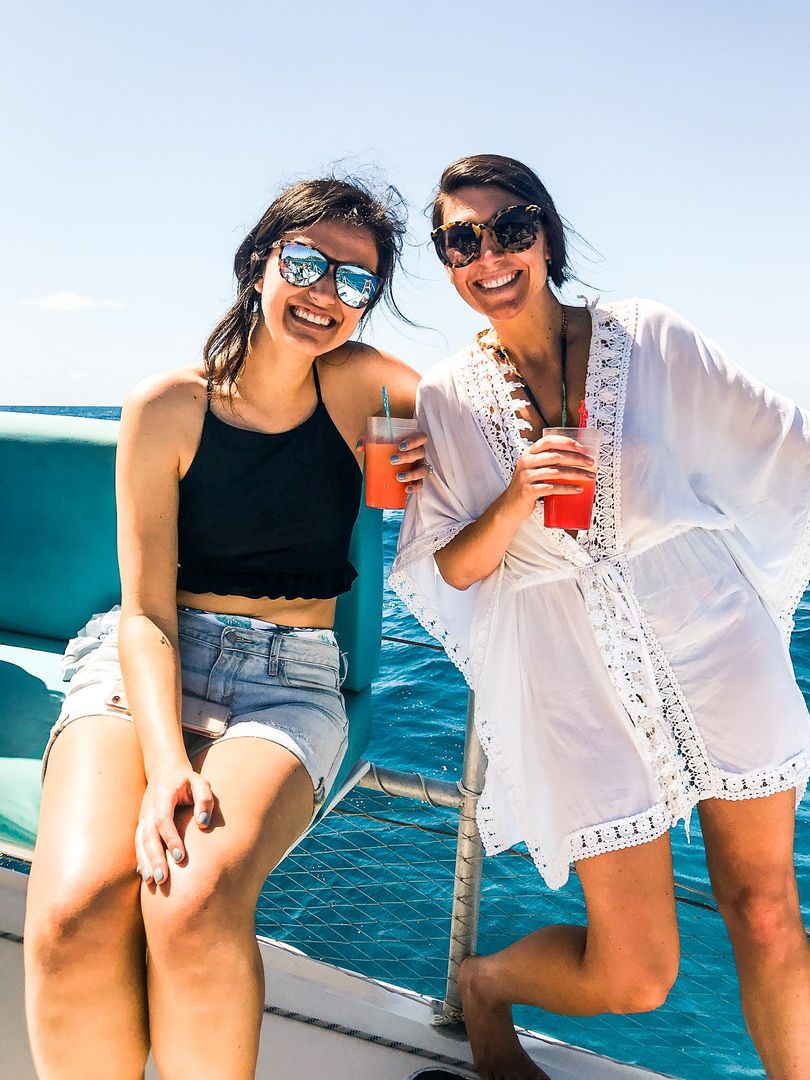 two women sitting on Random Wind yacht holding drinks