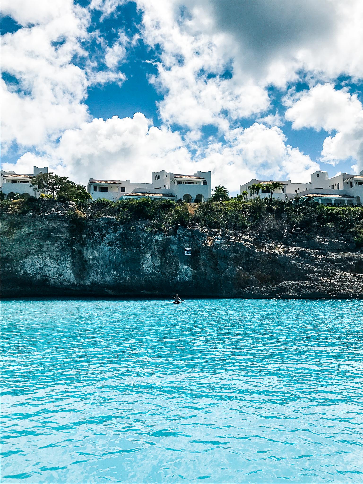 view of rock shore of sint maarten from water