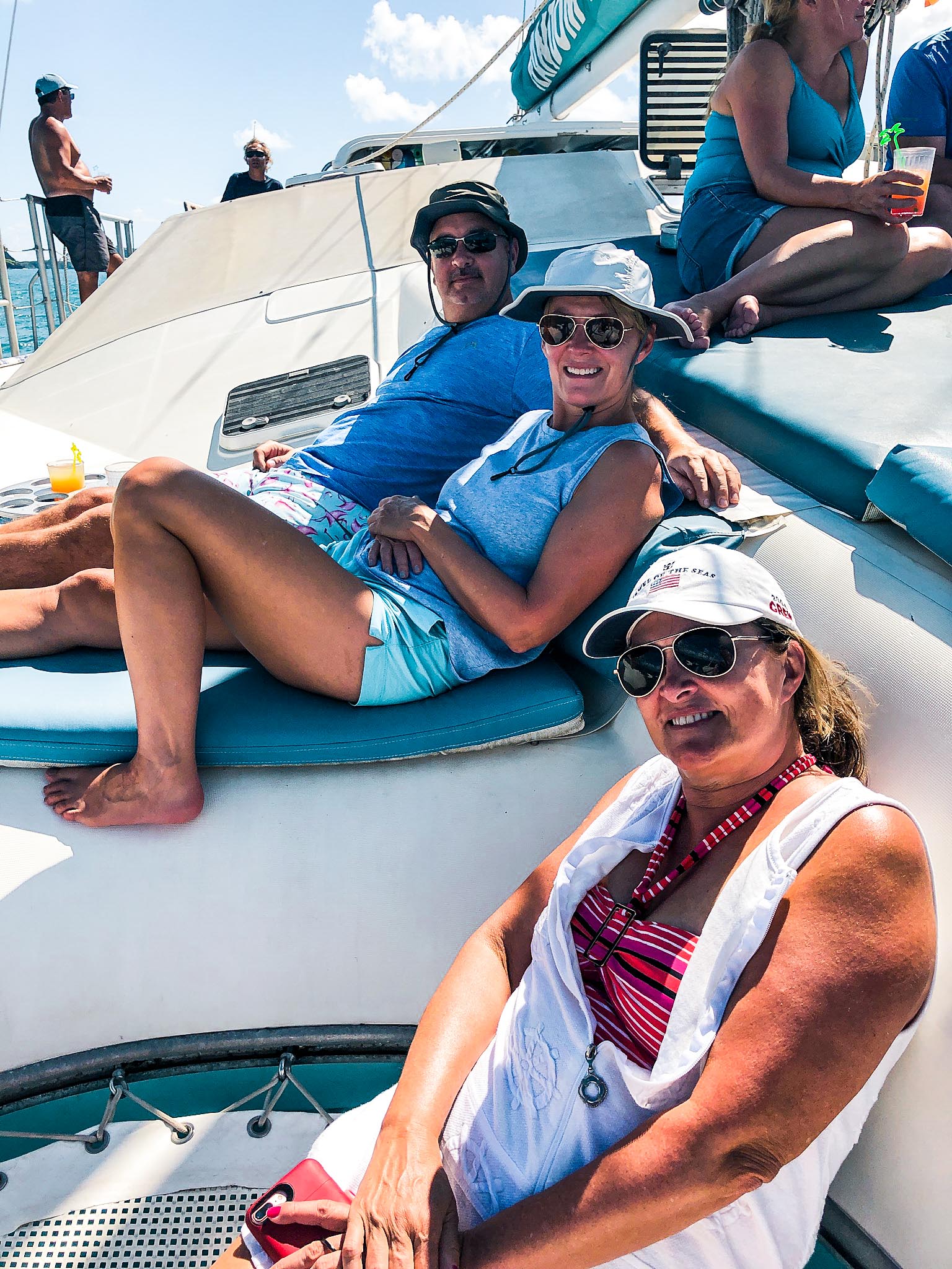 3 adults sitting on Random Wind catamaran