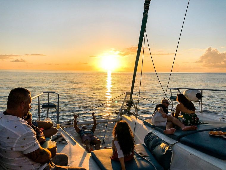 Family sitting on yacht charter during sunset
