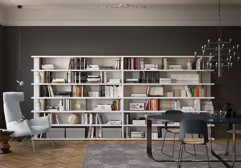 una stanza con dei mobili da libreria intorno di color nero e un divano al centro