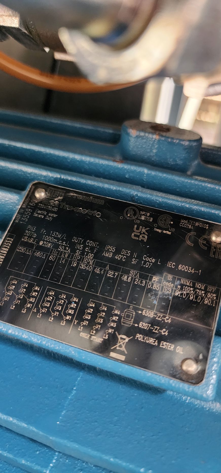 A close up of a blue electric motor with a label on it.