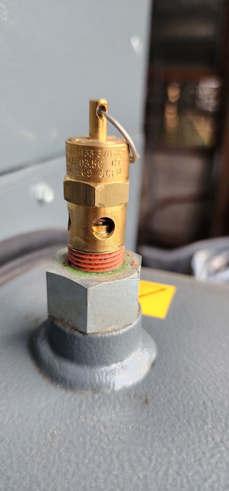 A close up of a brass valve on top of a metal object.